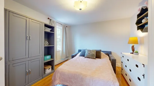 a bedroom with a bed and painting on the wall