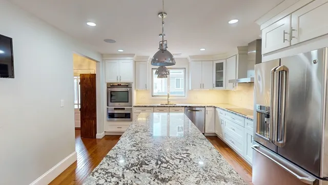 a large kitchen with kitchen island granite countertop a large counter top stainless steel appliances and cabinets