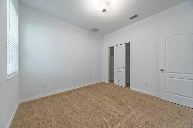 an empty room with windows and closet