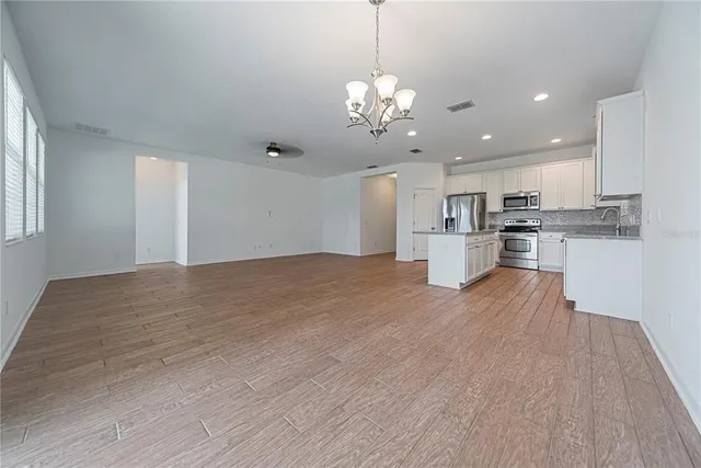 a view of a kitchen with a counter top space stainless steel appliances and a window