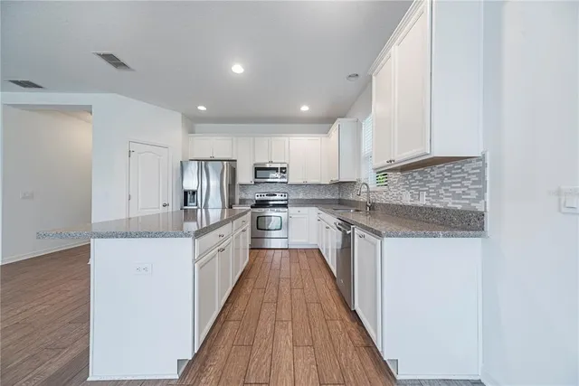 a kitchen with stainless steel appliances granite countertop a sink and cabinets