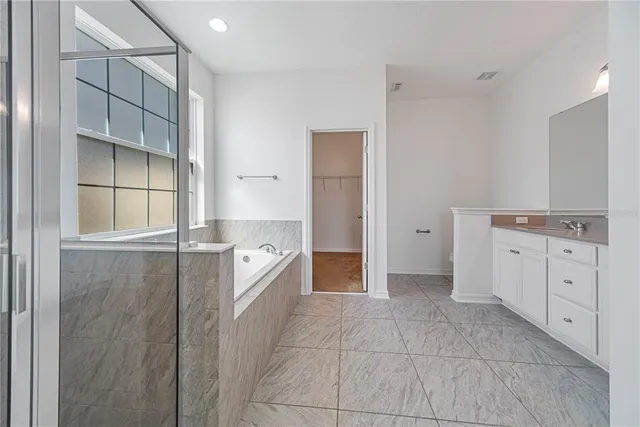 a large white kitchen with a sink and cabinets
