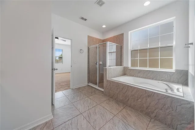 a spacious bathroom with a tub shower and sink