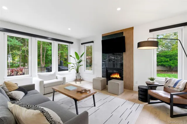 a living room with furniture a large window and a flat screen tv