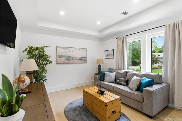 a living room with furniture flat screen tv and a large window