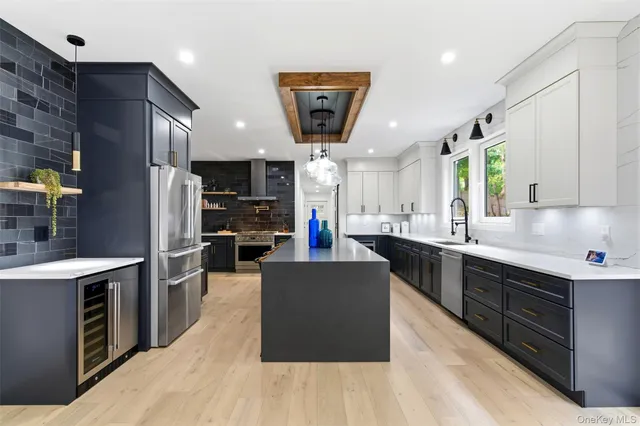 a kitchen with stainless steel appliances granite countertop a refrigerator a sink dishwasher a oven and a dining table with wooden floor