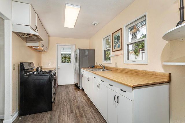 a kitchen with cabinets and wooden floor