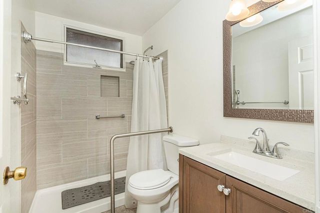a bathroom with a granite countertop sink toilet and shower