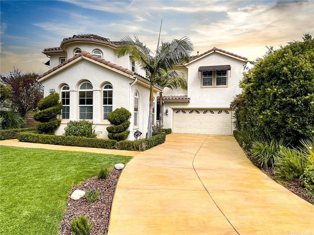 a view of a white house with a yard and potted plants