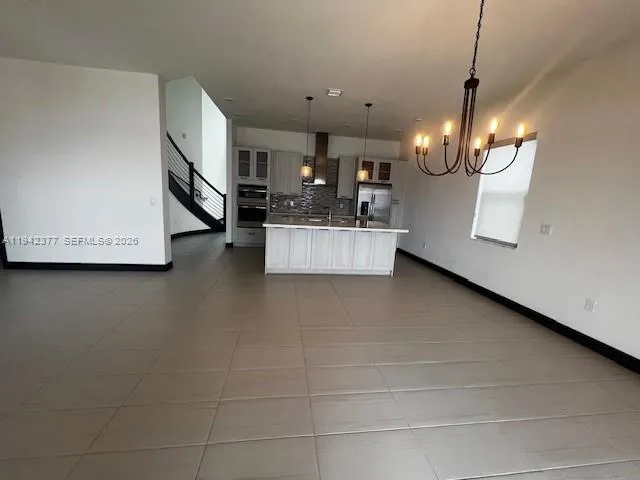 a view of a living room and kitchen with furniture and a flat screen tv