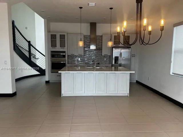 a kitchen with stainless steel appliances kitchen island granite countertop a sink a stove and a microwave