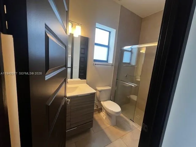 a bathroom with a granite countertop toilet and a shower