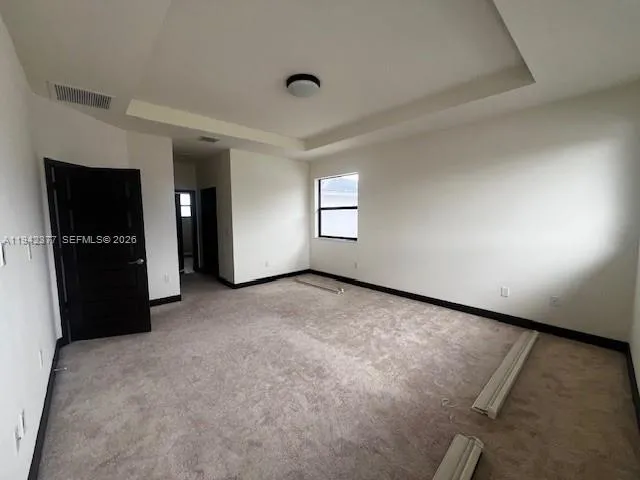 an empty room with closet and windows