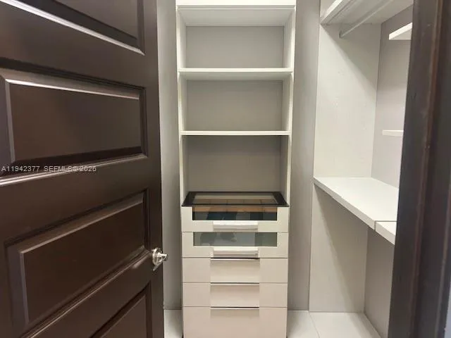 a view of walk in closet with empty racks