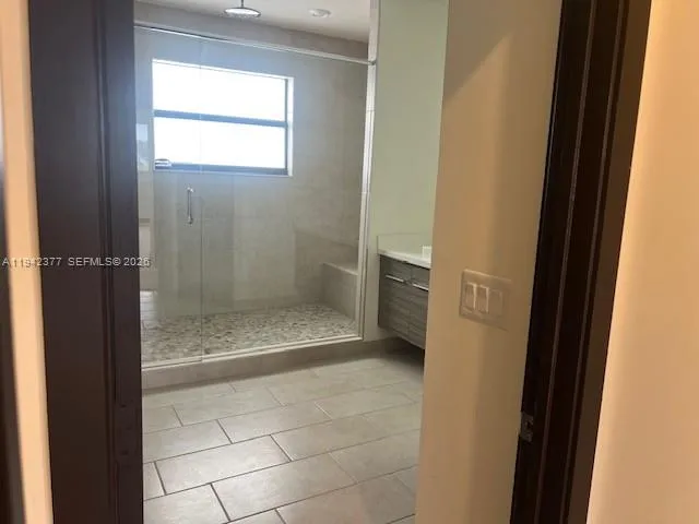 a bathroom with a glass door shower and a sink