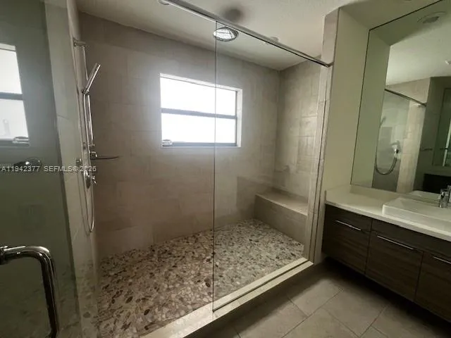 a bathroom with a sink a toilet a mirror and shower