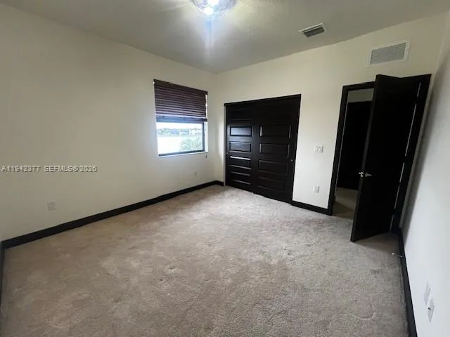 an empty room with a cabinet and a flat screen tv