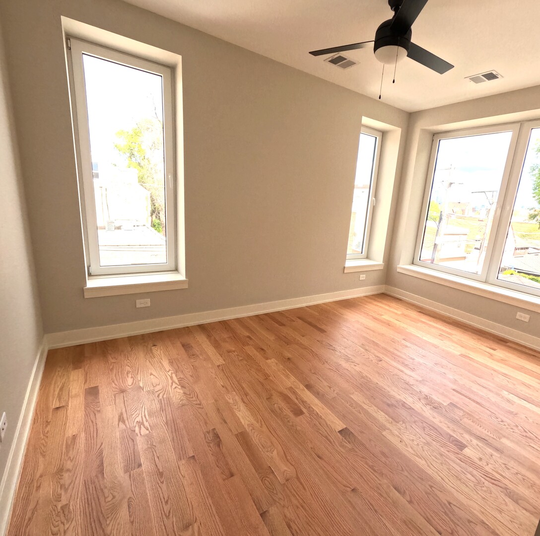 2100 West 18th Place, Unit 301 Chicago, IL 60608 - Photo 11 of 13 a view of an empty room with wooden floor and a window