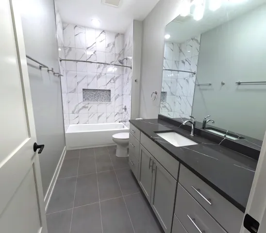 an empty room with wooden floor chandelier fan and windows
