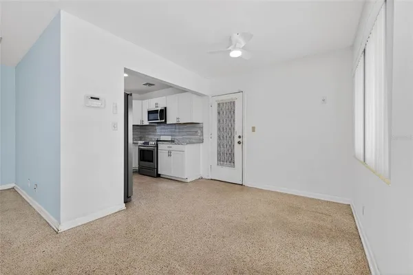 a view of a kitchen with a sink stove cabinets and empty room
