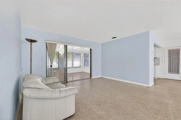 a living room with furniture and a glass door