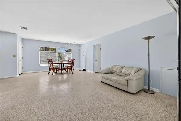 a living room with furniture and a dining table with projector