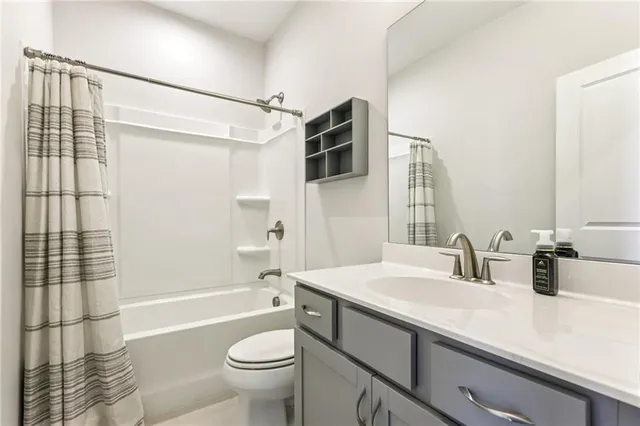 a bathroom with a sink a toilet a mirror and shower