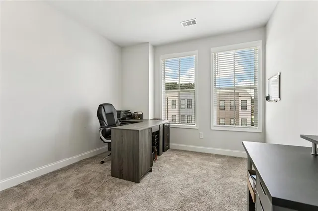 a view of a workspace with furniture and a window