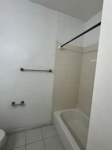 a bathroom with a granite countertop sink a toilet and bathtub