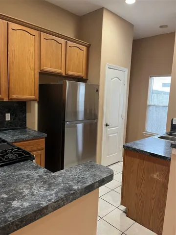 a kitchen with stainless steel appliances granite countertop a refrigerator and a sink