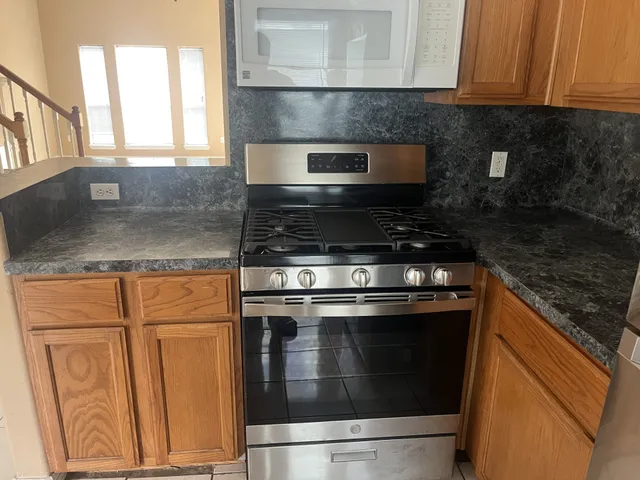a kitchen with granite countertop white cabinets and black appliances