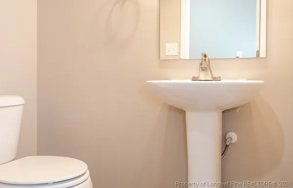 a bathroom with a sink a toilet and mirror