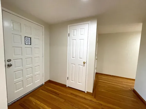 a view of empty room with wooden floor