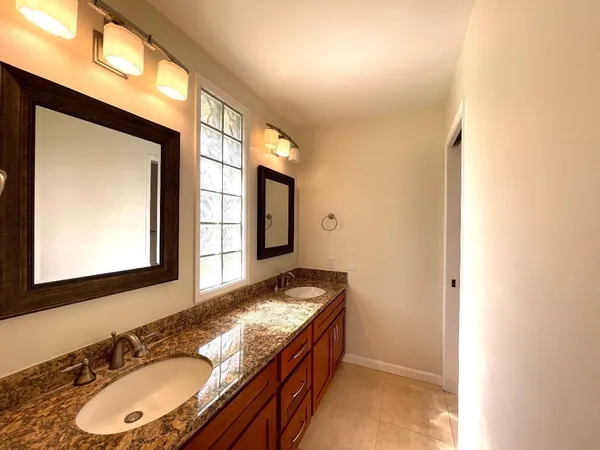 a bathroom with a granite countertop sink and a mirror