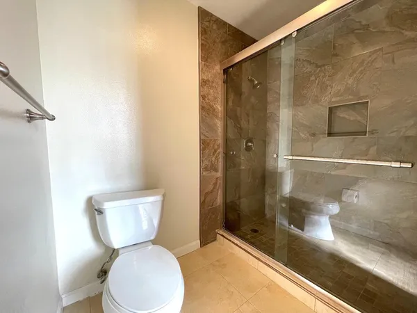 a bathroom with a toilet and a shower