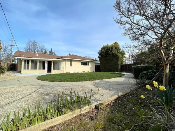 a front view of a house with a yard and trees