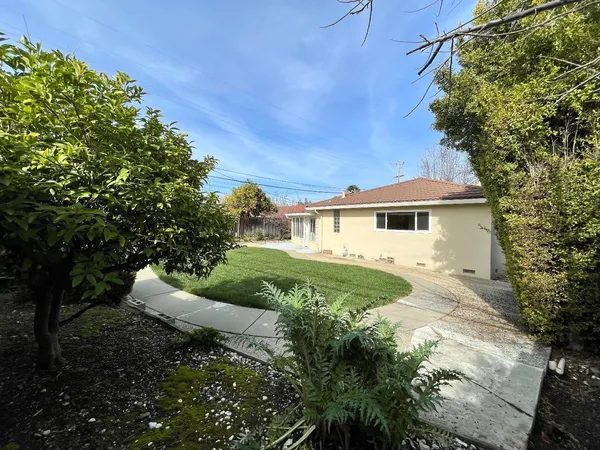 a view of a house with yard and a garden