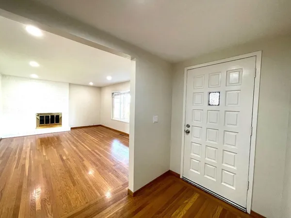 a view of empty room with wooden floor