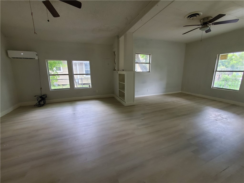 1107 14th Street Corpus Christi, TX 78404 - Photo 7 of 8 an empty room with windows and ceiling fan