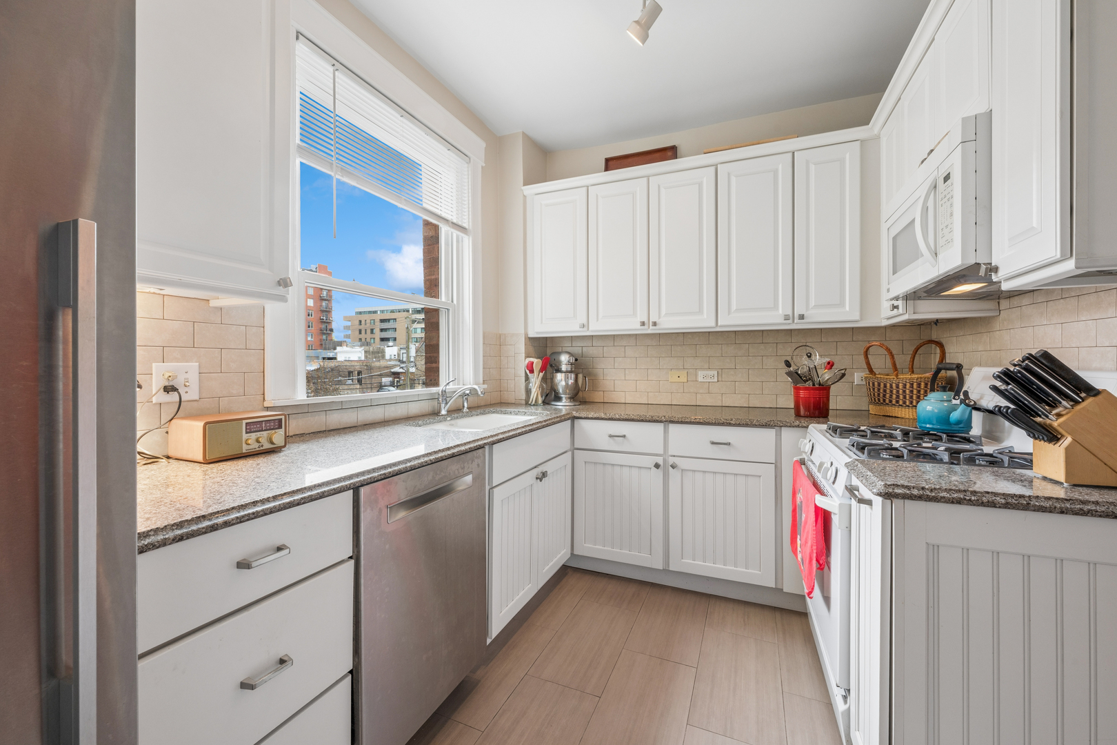 508 Lee Street, Unit 2E Evanston, IL 60202 - Photo 9 of 16 a kitchen with stainless steel appliances granite countertop a sink stove and cabinets