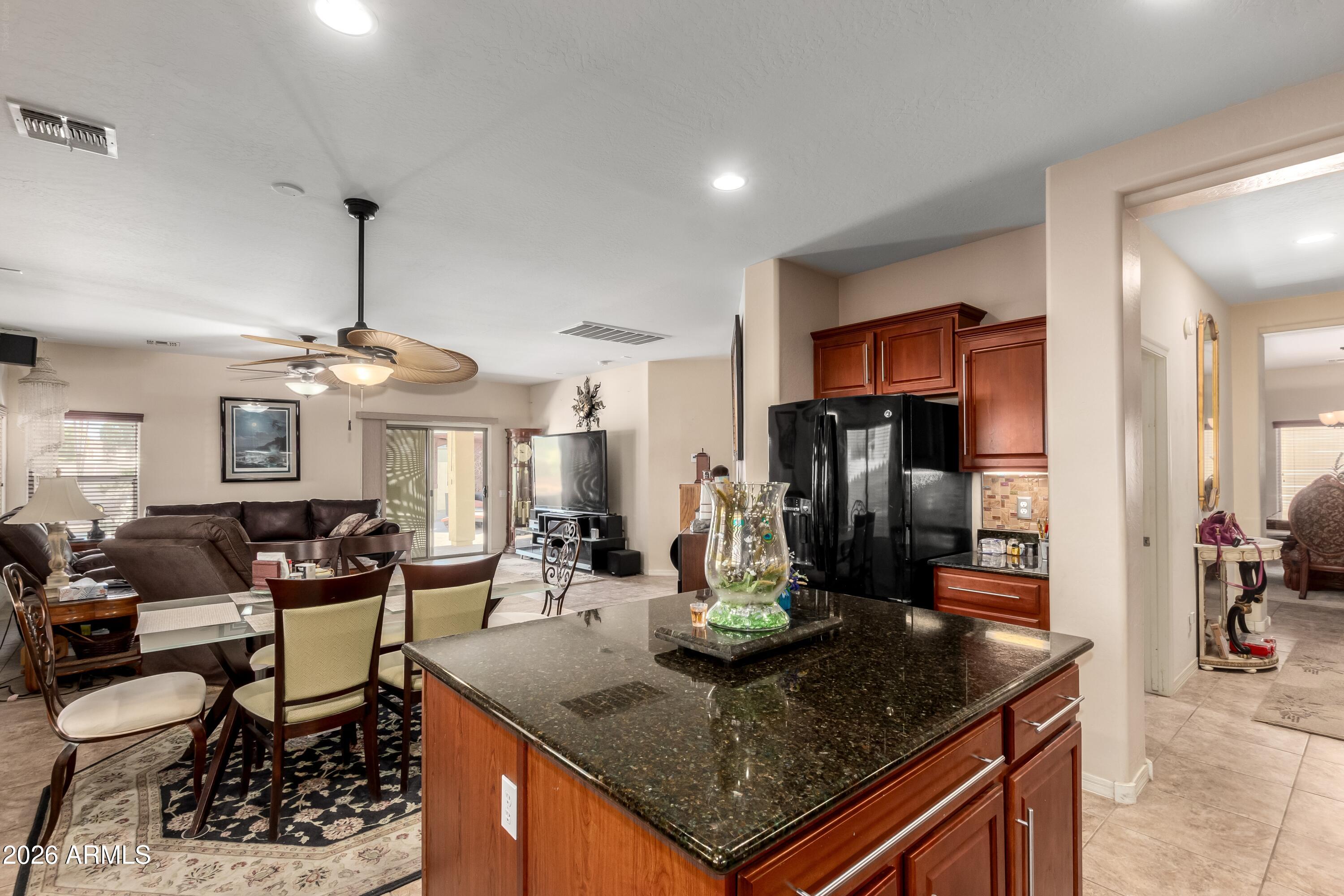 19221 North Toya Street Maricopa, AZ 85138 - Photo 13 of 22 a kitchen island with granite countertop a table and chairs