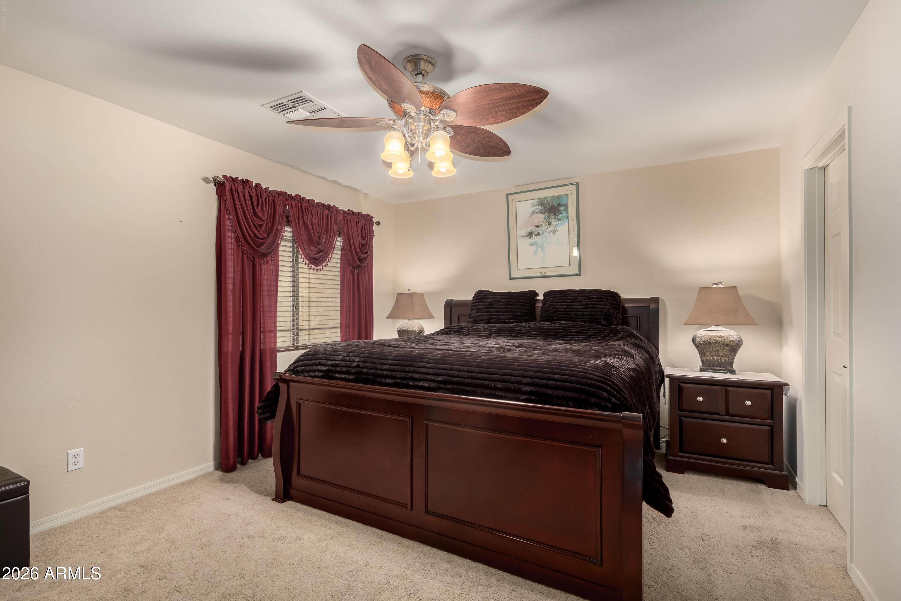 19221 North Toya Street Maricopa, AZ 85138 - Photo 21 of 22 a bedroom with a bed and a chandelier