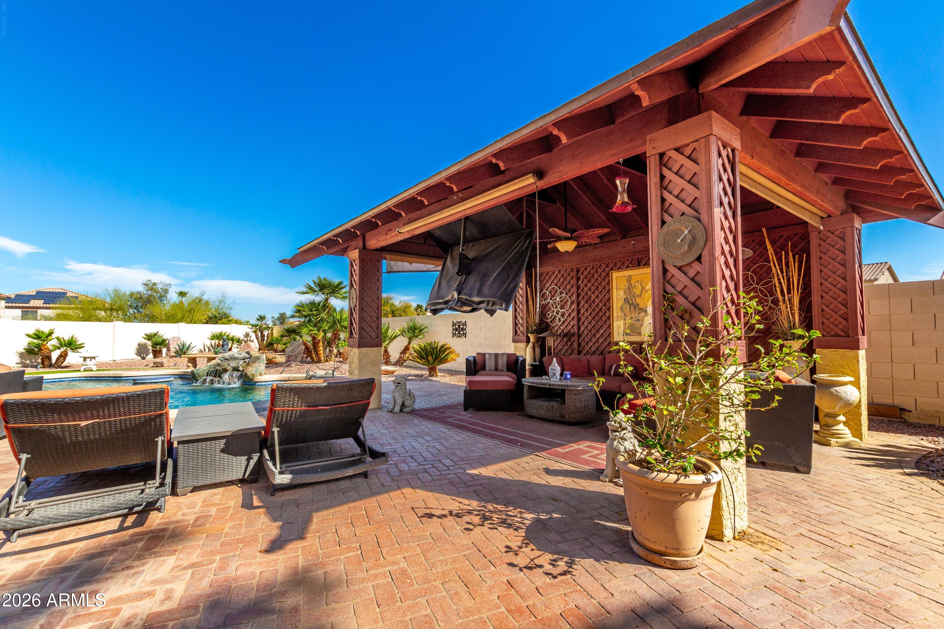 19221 North Toya Street Maricopa, AZ 85138 - Photo 7 of 22 a view of a patio with couches and chairs under an umbrella