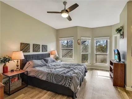 a bedroom with a large bed a chandelier and windows