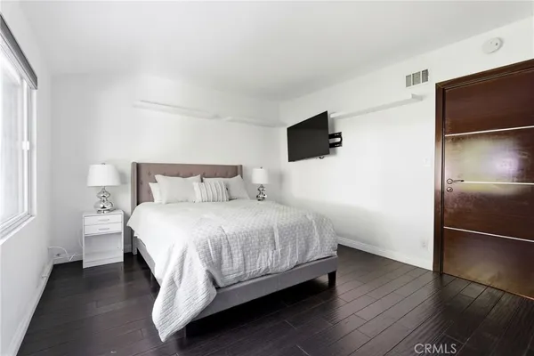 a bedroom with a bed and a flat screen tv