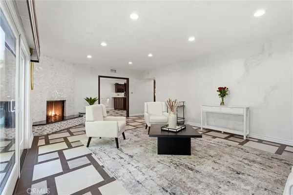 a living room with furniture a flat screen tv and a fireplace