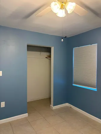 an empty room with a chandelier fan