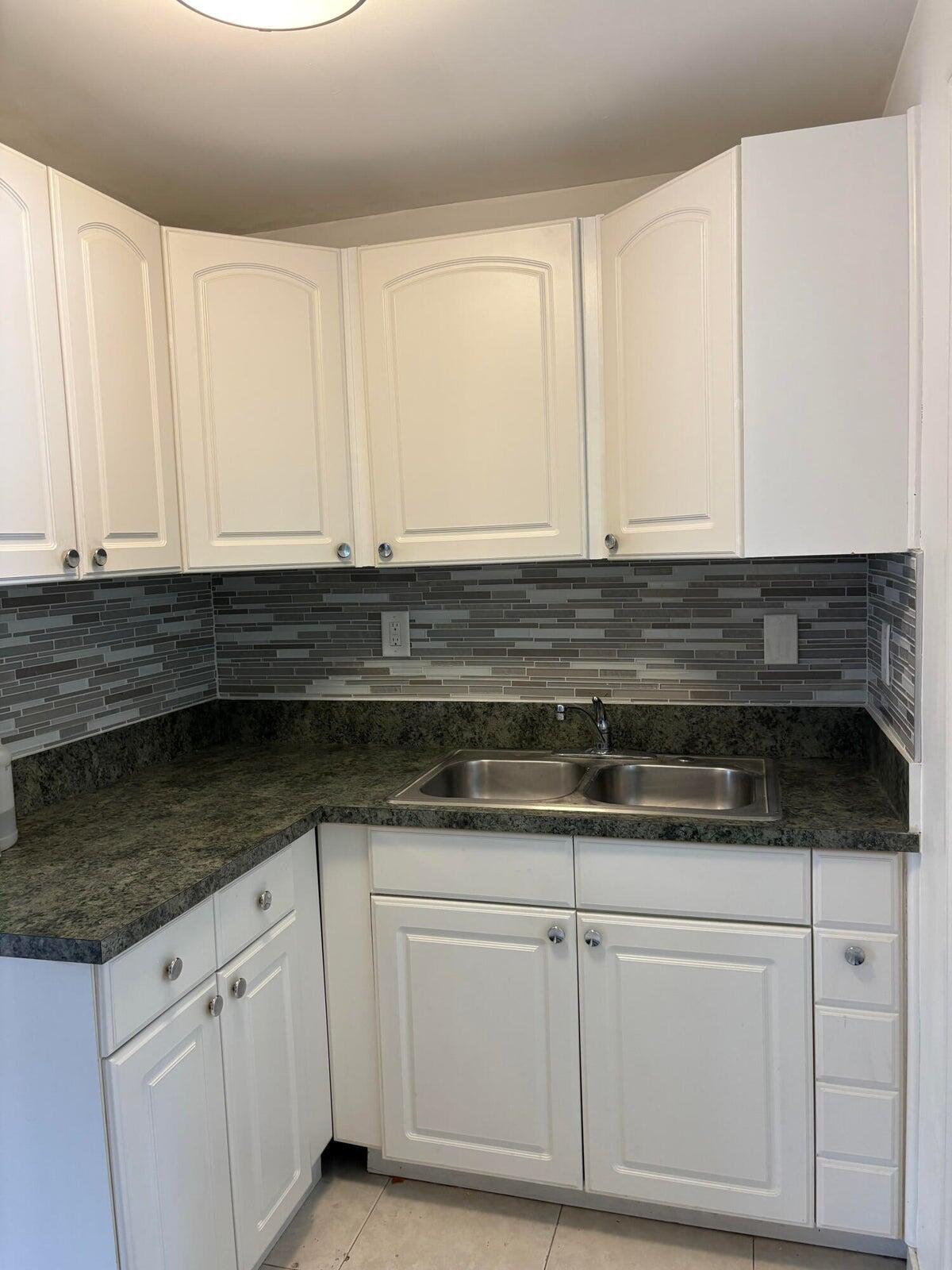626 Minnesota Street Lantana, FL 33462 - Photo 8 of 15 a kitchen with granite countertop white cabinets and a sink