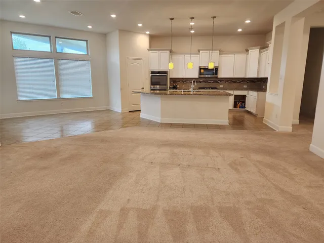 a view of a kitchen counter space a sink wooden floor and stainless steel appliances