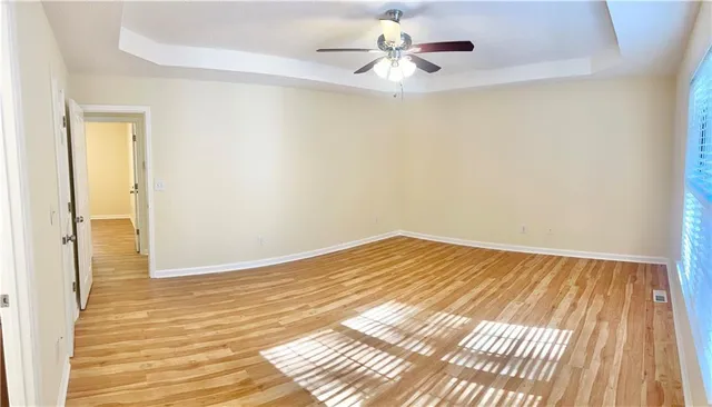 a view of a room with wooden floor and ceiling fan